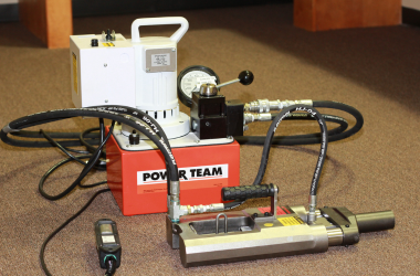 Hydraulic stressing machine for post-tensioning cables on a job site.